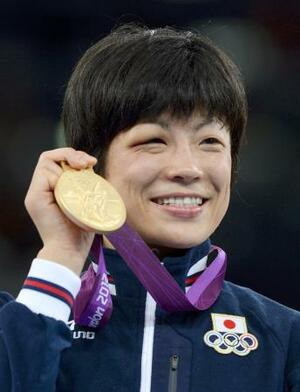 ロンドン五輪女子48キロ級で獲得した金メダルを手に笑顔を見せる小原日登美さん=2012年8月、エクセル(共同)