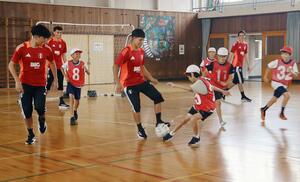 U-17ペルー代表の選手とサッカーで交流する牡丹山小学校の児童=新潟市東区牡丹山