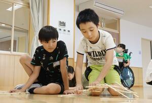 割り箸を使った橋作りに挑戦する東小の4年生=新発田市五十公野