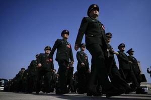 中国全人代の閉幕式に出席するため、人民大会堂に向かう人民解放軍の代表ら=2024年3月、北京(共同)