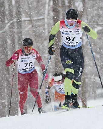 女子５キロクラシカル上り坂で競り合う牧田鈴葉（左・７０十日町）と丸山萠衣（６７・十日町総合）＝２月９日、北海道名寄市のなよろ健康の森クロスカントリーコース