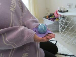 乳児の遺骨が入った容器を持つナギサさん=2023年3月