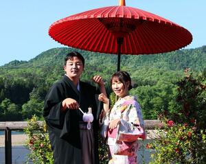 2024年の「つがわ狐の嫁入り行列」の花嫁花婿に選ばれキツネのポーズをする黒澤舞さん(右)、怜央さん=5月3日、阿賀町津川