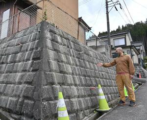 能登半島地震で擁壁に被害を受けた会社員男性。修復したものの地区を離れることを決めた=糸魚川市京ケ峰1