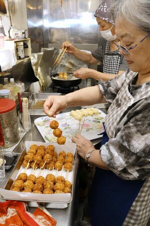 販売当日に行われるイカメンチの調理風景。朝のうちに具材を切り、揚げる作業まで行う=弥彦村弥彦