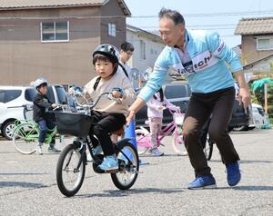 補助輪なしで自転車に乗る練習をする参加者=27日、新潟市東区