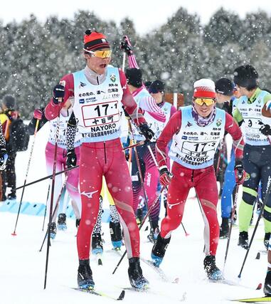 男子40キロリレー 十日町の1走佐藤五輪(左)から2走岡田幸輝にリレー=2月11日、北海道名寄市