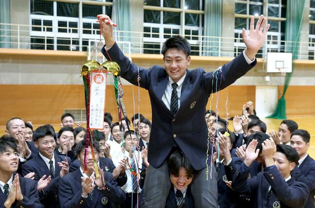 ソフトバンクから育成１位で指名された関根学園の池田栞太捕手。肩車で祝福される＝上越市の関根学園高校