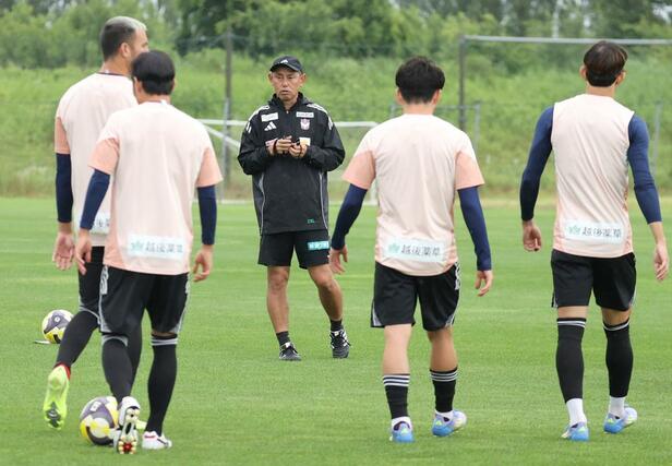 初采配前日の練習で選手を集める入江徹新監督(中央)=6月24日、聖籠町
