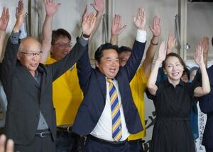 香川選挙区で当選を決め、支援者らと万歳する国民民主党の原田秀一氏(中央)=20日夜、高松市