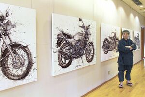 オートバイを描いた作品の前に立つ遠藤信さん=2023年6月、新潟市西蒲区