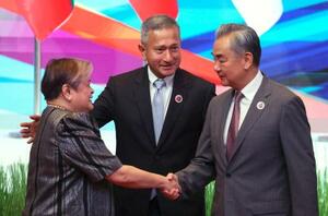 中国ASEAN外相会議で、フィリピンのラザロ外相(左)と握手する中国の王毅外相=10日、マレーシア・クアラルンプール(AP=共同)