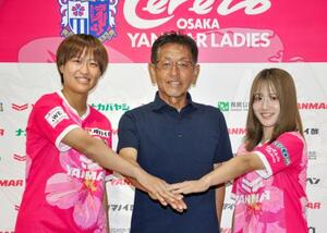記者会見後、宝田(左)らとポーズをとるWEリーグC大阪ヤンマーの松田岳夫新監督=9日、ヨドコウ桜スタジアム
