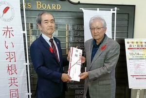 寄付金の目録を手渡す日本防災士会県支部長の松岡輝彦さん(右)=新潟市秋葉区の新津カントリークラブ