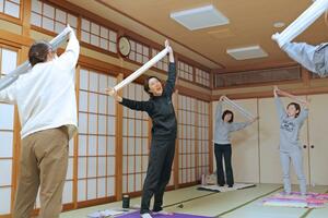 「フライデーナイトカフェ」で自力整体を教える地域おこし協力隊の加峰真理さん（左から二人目）＝長岡市西新町２