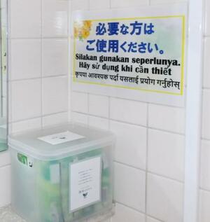 　湖池屋の工場トイレに設置された「職場のロリエ」。複数の言語で「必要な方はご使用ください」と書かれている