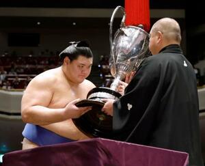 大相撲秋場所で、横綱として初となる優勝を果たし、日本相撲協会の八角理事長(右)から賜杯を受け取る大の里=28日、東京・両国国技館