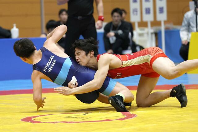 団体戦２回戦　八海－自由ケ丘学園（東京）　低いタックルを仕掛ける佐藤来人（赤・八海）＝新潟市東総合スポーツセンター