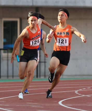 男子４００メートルリレー決勝、東京学館の３走三浦朋来からアンカー松本塁にバトンパス＝６月１４日、新潟市中央区のデンカビッグスワン