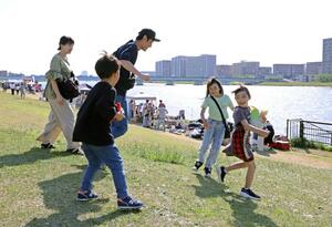 強い日差しが照りつける中、半袖姿で遊ぶ親子連れら=5月5日、新潟市中央区