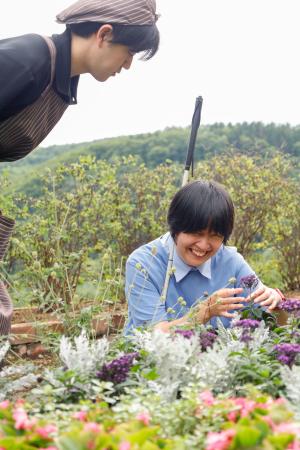 「香りの里ハーブガーデン」で花の匂いを楽しむ片岡裕里さん(右)=7月、北海道滝上町