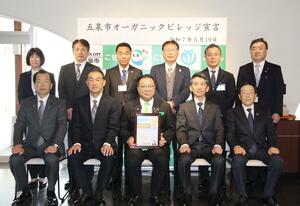 「オーガニックビレッジ宣言」の宣言書を掲げる田辺正幸市長(前列左から3番目)=19日、五泉市赤海