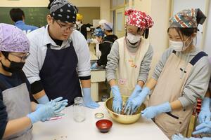 海洋高の生徒に教わりながら魚醬造りに挑戦する八千浦小の児童たち=上越市下荒浜