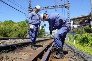 猛暑の中、レールを点検する近鉄の作業員=8月、大阪府羽曳野市