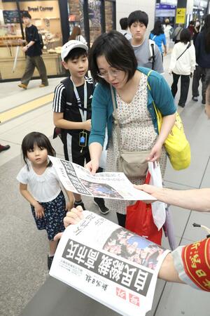 号外を受け取る駅利用者=JR新潟駅