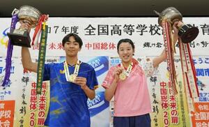表彰式を終え、笑顔でトロフィーを掲げる男子シングルス優勝の星槎国際横浜・川上(左)と女子シングルス優勝の山陽学園・面手=JCOMアリーナ下関