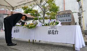 　土砂災害発生から１１年となり、広島市立梅林小の慰霊前に設けられた献花台＝２０日午前