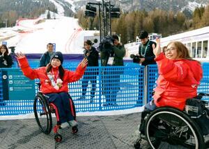 　アルペンスキー女子大回転座位で銀メダルを獲得し、日本選手団の大日方邦子団長（右）と手を振る村岡桃佳＝１２日、イタリア・コルティナダンペッツォ（共同）