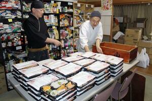 子どもたちへ贈る恩送りエール飯弁当の準備をする大桃秋弘さん(左)ら=三条市北新保1