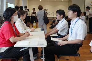 催しで高校生と対話する福嶋美佳さん(左手前)=新潟県十日町市