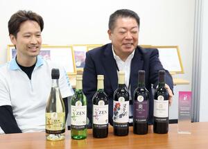 金賞を受賞した岩の原葡萄園のワインと、遠藤正義社長(右)と上野翔さん=上越市北方