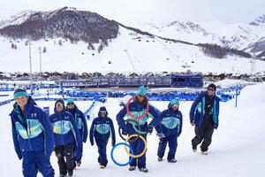 「ギャングみたいだろ?」。五輪のモニュメントを首から提げておどけるスタッフ。一見、お宝を強奪してきたように見えますが、むしろみんなの心が、五輪に奪われてしまったのかもしれません=リビーニョ(共同)