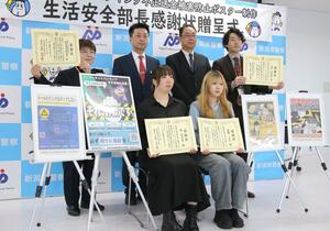 不正送金被害の防止を訴えるポスターを作った開志専門職大の学生ら＝新潟市中央区古町通７