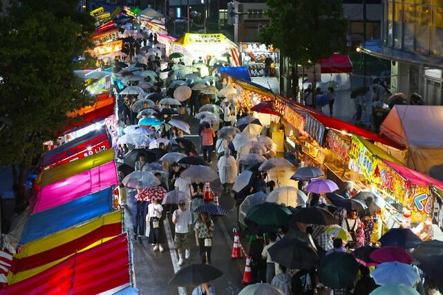 激しく雨が降る中、大勢の来場者でにぎわったえんま市＝１４日、柏崎市