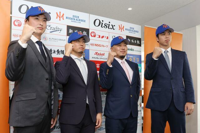 会見後、写真撮影に応じる左から石川直也投手（元日本ハム）、井口和朋投手（元オリックス）、松山竜平外野手兼打撃コーチ（元広島）、宮森智志投手（元楽天）＝１６日、新潟市中央区のエコスタ