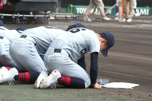 中越－関東第一　ベンチ前で甲子園の土を集める中越の選手たち＝甲子園