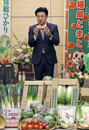 茨城県の農業関係者らから贈られた「こだますいか」を堪能する木原官房長官=7日午前、首相官邸