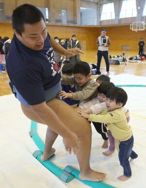 海洋高校相撲部員の胸を借りて相撲を楽しむ子どもたち=12月14日、糸魚川市能生
