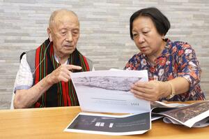 写真を見ながらインパール作戦での様子を語る佐藤哲雄さん(左)と話を聞くアジャヌオ・ベルホさん=8月23日、新潟市中央区