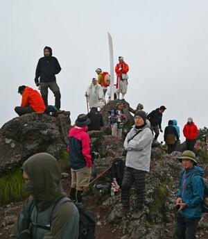 解禁された男体山夜間登山に参加し、山頂で日の出を待つ登山者たち。この日、御来光は拝めなかった=1日午前4時45分ごろ、栃木県日光市