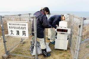 東京電力柏崎刈羽原発近くに可搬型のモニタリングポストを設置する県職員＝１９日、柏崎市