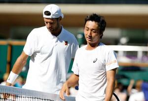 男子シングルス2回戦で敗れた望月慎太郎(右)=ウィンブルドン(共同)