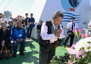 「洋上慰霊」の慰霊式で手を合わせる元島民=20日午後、北海道羅臼町沖(代表撮影)