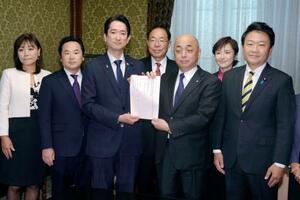 衆院の築山信彦事務総長(右から3人目)に「空室税」導入法案を提出する国民民主党の議員ら=11日午後、国会