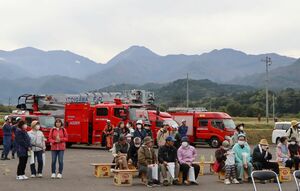 焼山噴火を想定した避難訓練で一時集合場所に集まる住民ら=10月26日、糸魚川市