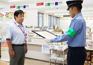 感謝状を受け取る越後上田郵便局長の上村真也さん(左)=南魚沼市長崎